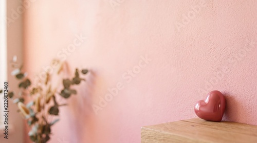 Minimalist Red Heart on Wooden Shelf Against Pink Wall
