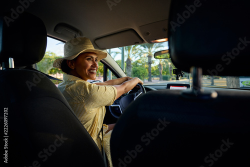 Woman driving car enjoying tropical road trip vacation