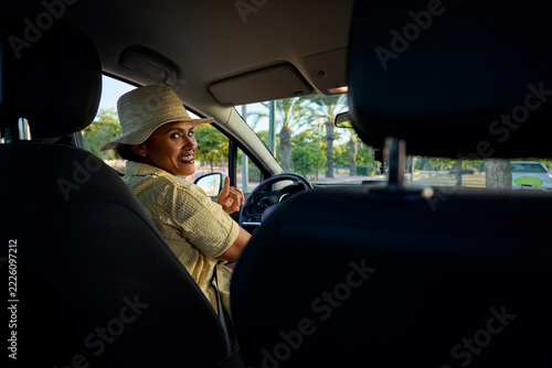 Happy woman driving car enjoying summer road trip