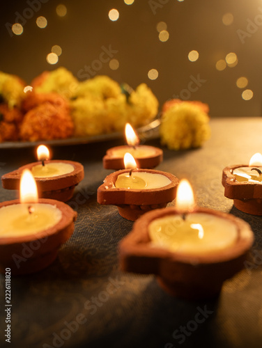 Traditional Clay Diya with a Lit Flame Against a Dreamy Warm Golden Bokeh Background, Festive Diwali Close-Up Shot

