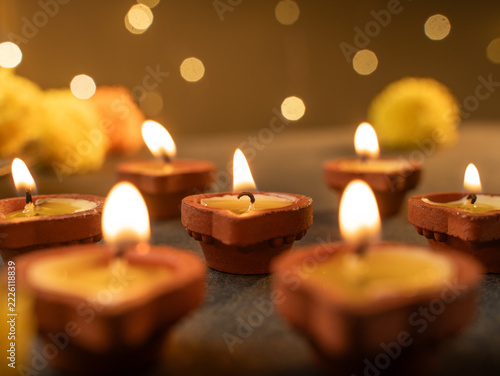 Traditional Clay Diya with a Lit Flame Against a Dreamy Warm Golden Bokeh Background, Festive Diwali Close-Up Shot
