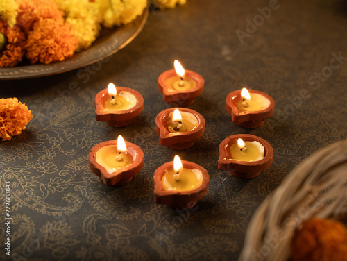 Traditional Clay Diya with a Lit Flame Against a Dreamy Warm Golden Bokeh Background, Festive Diwali Close-Up Shot
