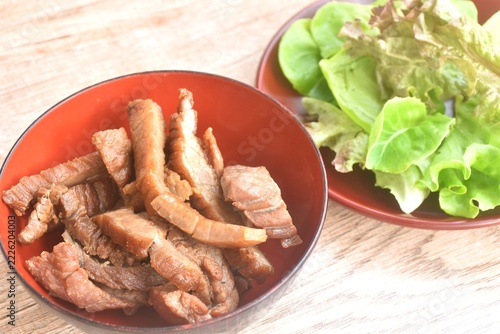 fried slice salty beef meat in bowl with mixed vegetable salad on plate 