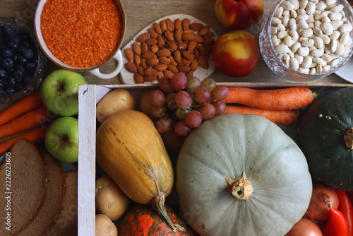 Various healthy fruits and vegetables, legumes, nuts and wholegrain bread on the table. Flat lay.