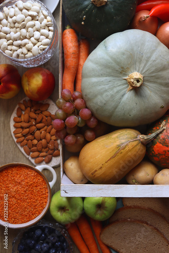 Various healthy fruits and vegetables, legumes, nuts and wholegrain bread on the table. Flat lay.