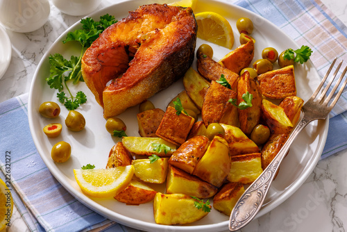 Pan seared salmon steak with potato wedges