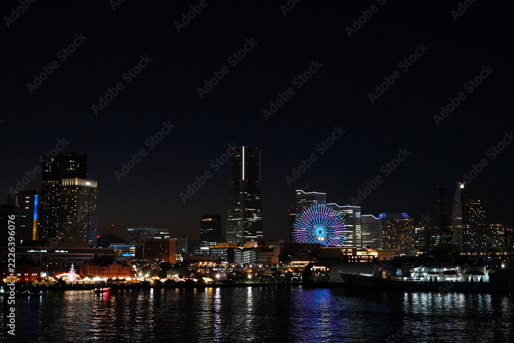 Fototapeta premium 海に映るみなとみらいの夜景と観覧車 冬の横浜 夜空のコピースペース