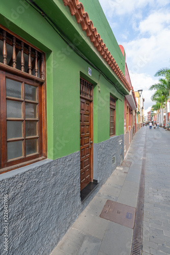 Charming historic architecture with vibrant green building facade and wooden windows in Puerto de la Cruz, Canary Islands