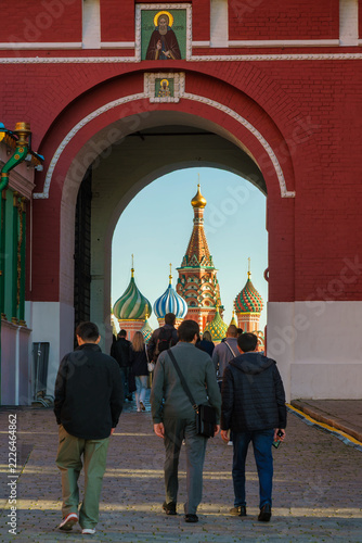  St Basil's Cathedral framed by a red brick archway with people walking toward Red Square, Moscow