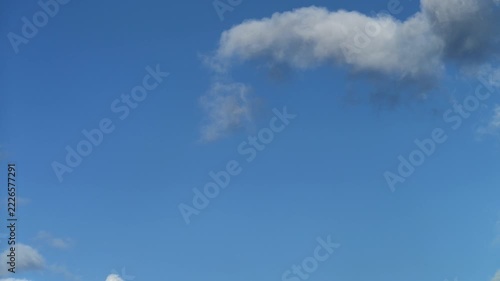 Time-lapse of fluffy white cumulus clouds moving across blue sky
