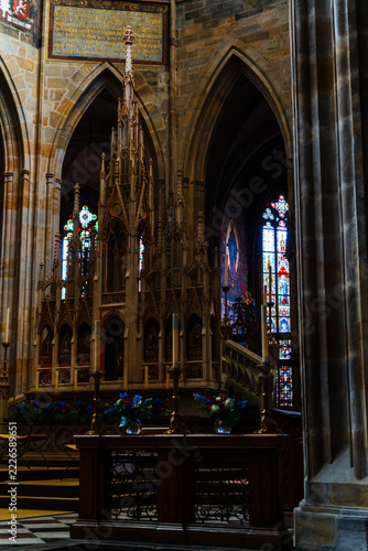 Prague, Czechia - 05 October 2026: View of the ornate Gothic altar and stained glass windows inside St. Vitus Cathedral, featuring intricate stone carvings and religious iconography.