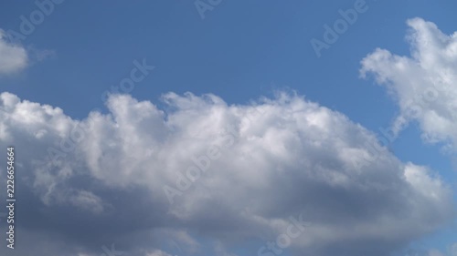 Time-lapse of fluffy white cumulus clouds moving across blue sky
