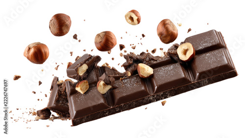 Floating Dark Chocolate Bar Pieces with Hazelnuts and Crushed Chocolate Crumbs in Dynamic Composition Isolated on Transparent Background