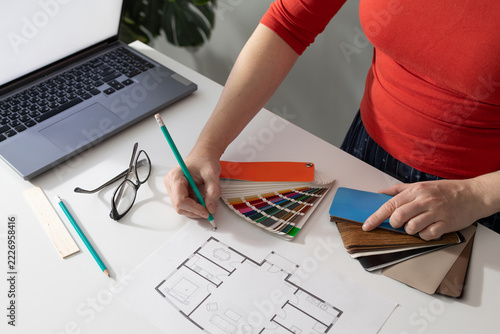 Designer selecting a color shade from a swatch fan to create an interior color scheme