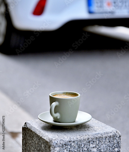 A cup of espresso sitting on a stone.