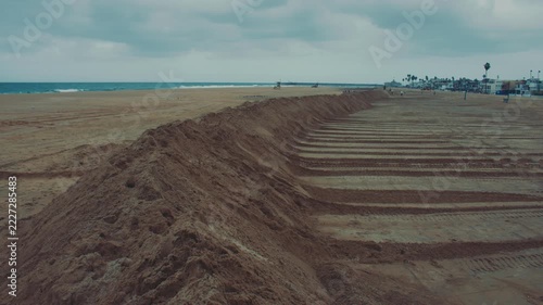 Large sand barriers form protective ridges along Newport Beach to reduce the risk of storm floods.