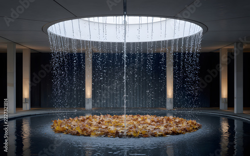 Water cascading into pool with fallen leaves during daytime with architectural setting