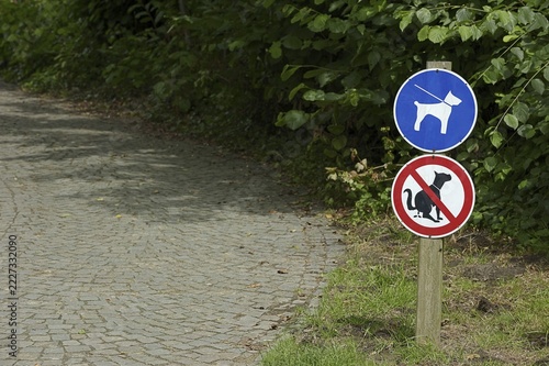 Signs 'Dog excrement prohibited' and 'Dogs on a lead' in a park, North Rhine-Westphalia, Germany