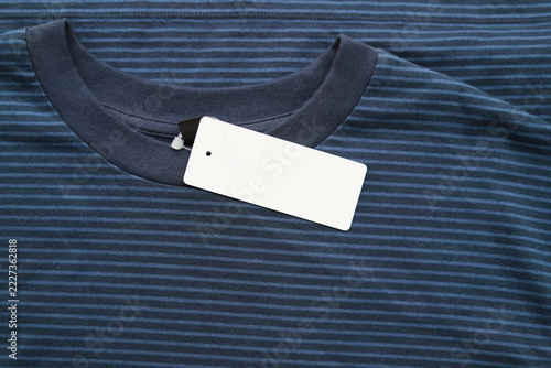 Top view of navy blue striped t-shirt with blank white price tag tag mockup