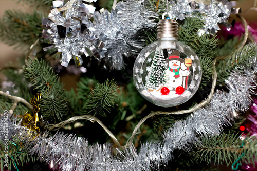 Christmas Tree Decoration with Snowman Glass Ornament and Silver Tinsel Garland, Festive Holiday Background