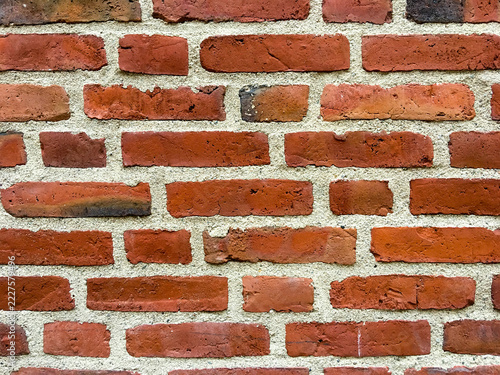 Close up of weathered red brick wall with light mortar joints