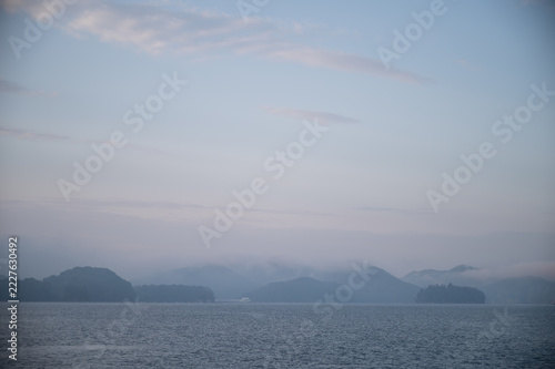 Wide sky with light clouds over morning fog and sea at dawn