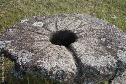 Ancient stone millstone with a hole in the center.
