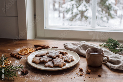 Winter baking scene with cookies, hot drink, and decorative elements near a snowy window