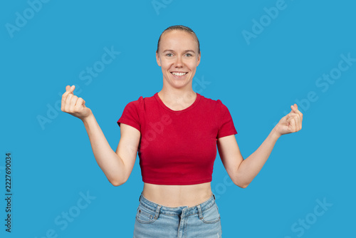 Woman making mini-heart hand gesture smiling at camera