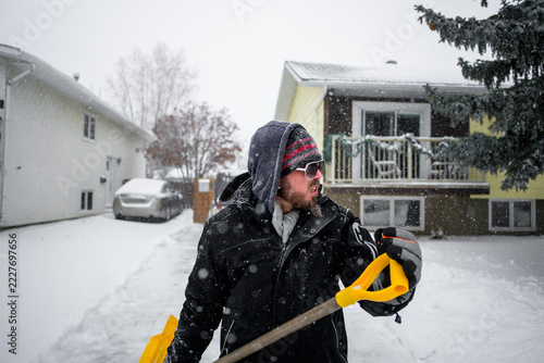 Man remove snow from porch during winter storm