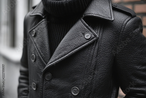 Man in black leather jacket and turtleneck sweater.