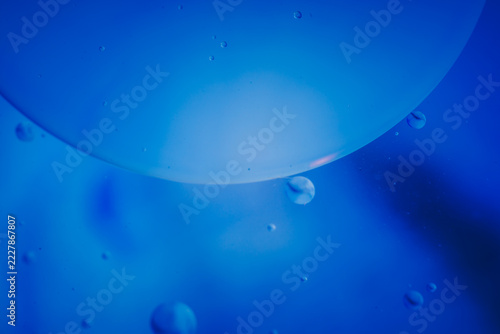 Fotografie Abstract blue liquid with floating bubbles creating a tranquil, underwater-like atmosphere