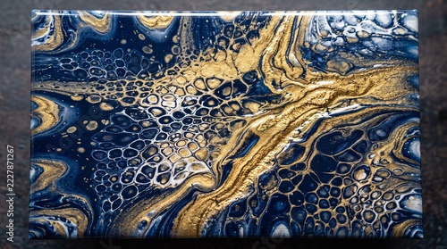 Abstract liquid resin painting with blue and gold swirling marble