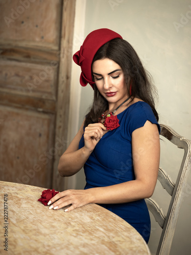 Lady in red hat with rose on blue dress