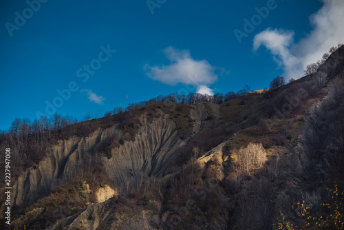 Landscape with beautiful fog in forest on hill or Trail through a mysterious winter forest with autumn leaves on the ground. Road through a winter forest. Magical atmosphere. Azerbaijan nature