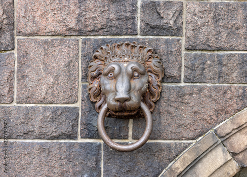 A cast iron head of lion with a ring in its mouth on the wall of a building in Stockholm. Sweden