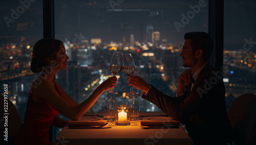 夜景の見えるレストランでワイングラスを合わせる二人
