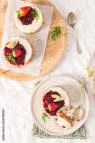 Mini berry cheesecakes served on plate and wooden tray