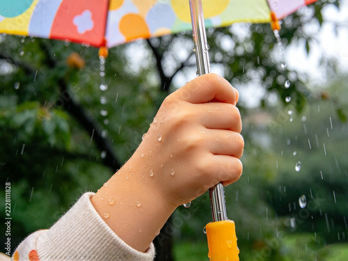 a small child's hand holding an umbrella