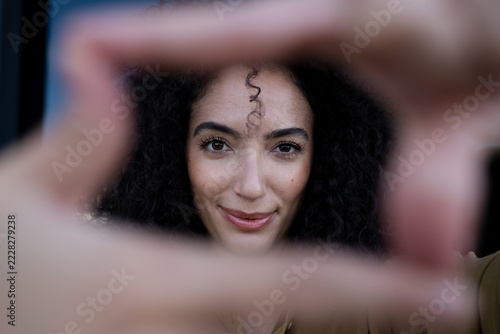 Close-up portrait of a smiling woman with curly hair framing her face