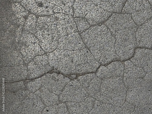 Fotografie Rough Grey Surface with Irregular Cracks and Weathered Texture