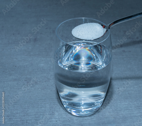 Glas mit Medikamentenpulver neben Tabletten