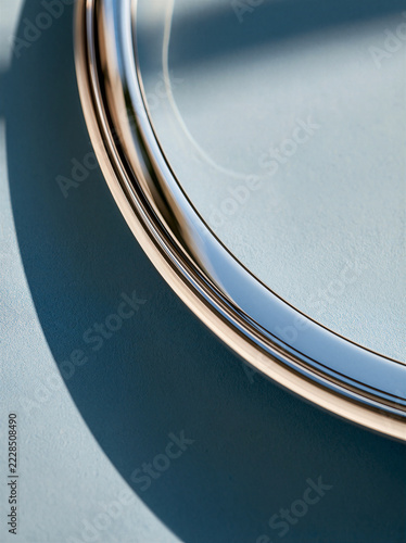 Close up of a slim silver laptop edge resting against a powder blue surface
