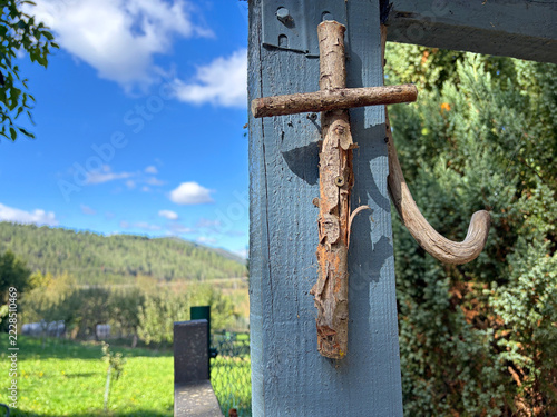 cruz de madera sobre un poste de madera gris en la entrada de una casa país vasco oñate IMG_9693-as26