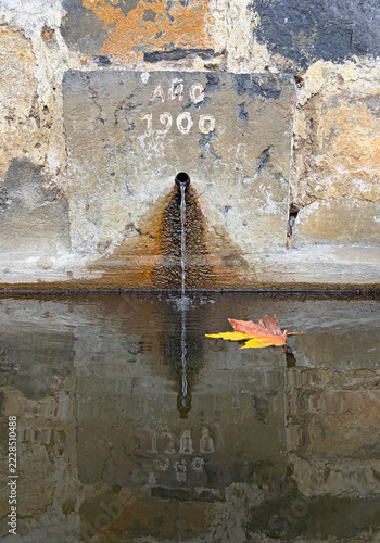 fuente de agua potable pública con una hoja de otoño en el agua en un pueblo rural del país vasco oñate IMG_9743-as26