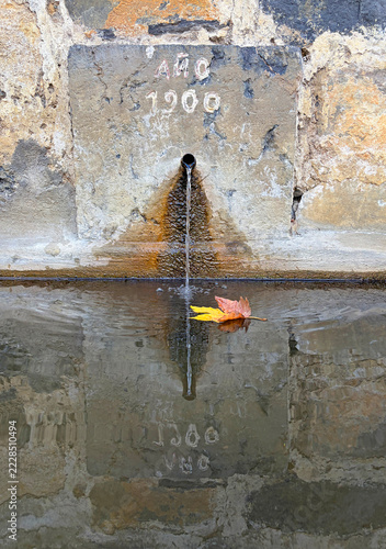 fuente de agua potable pública con una hoja de otoño en el agua en un pueblo rural del país vasco oñate IMG_9735-as26