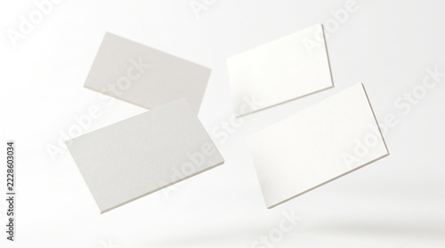 Blank white business cards floating in mid-air with soft shadows
