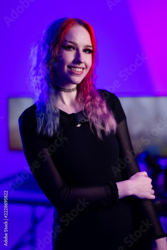 Young woman with vibrant hair in a purple ambient light environment