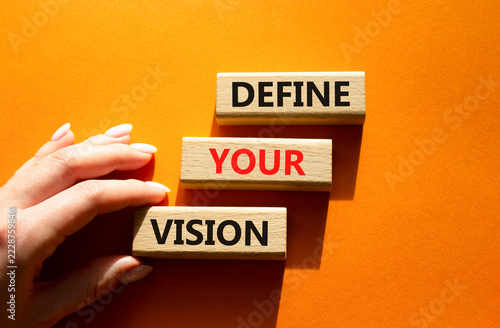  Concept words define your vision on wooden blocks arranged as steps. Businessman hand arranging wooden blocks. Strategic planning and goal setting concept. Orange background. Copy space.
