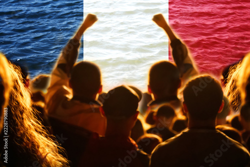 Obraz na plátně Silhouette of protesting crowd with raised fists against France national flag background